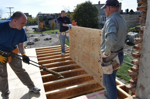 Add construction adhesive before laying a plywood subfloor.